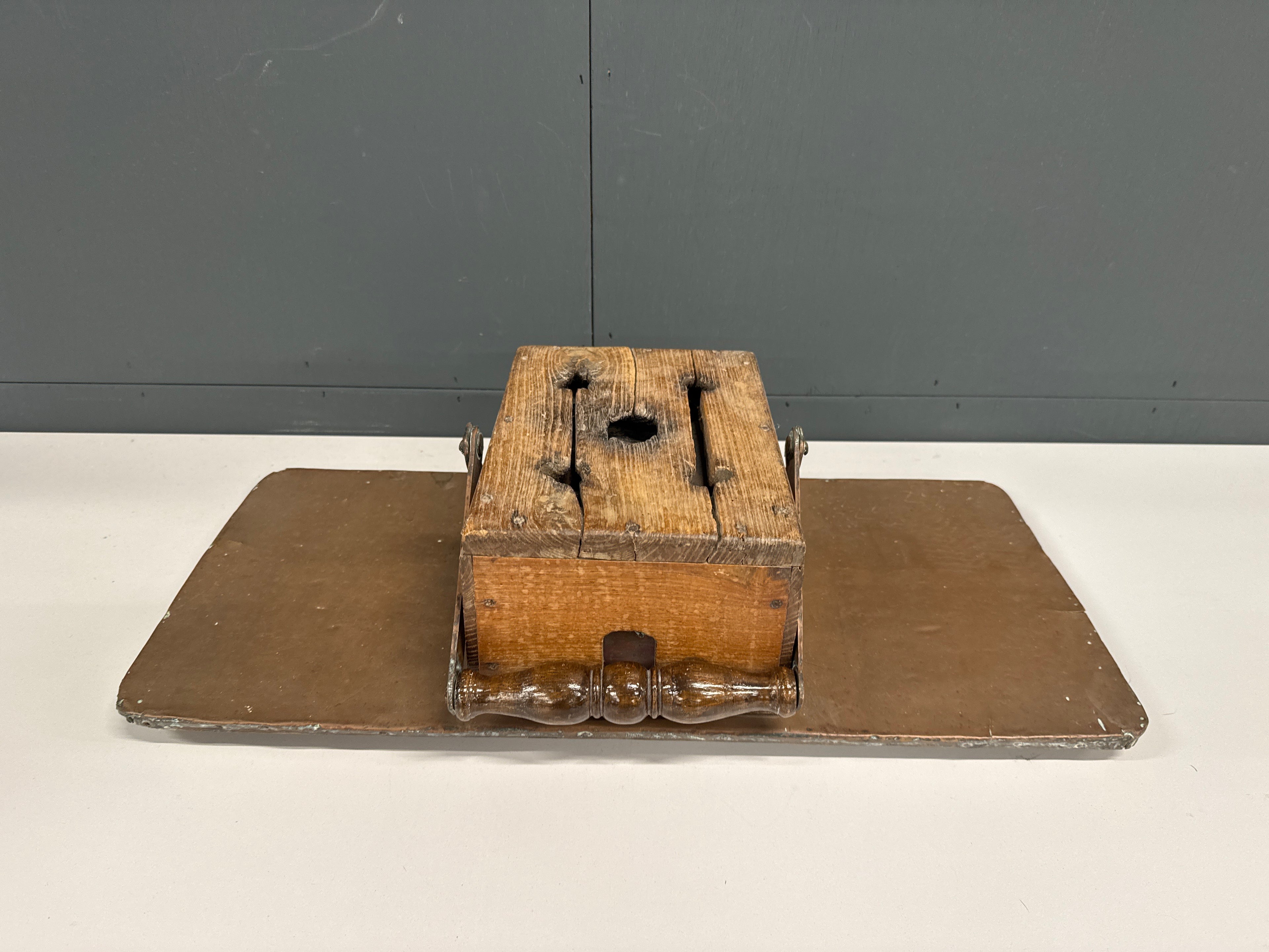 Antieke voetstoof op koperen plaat